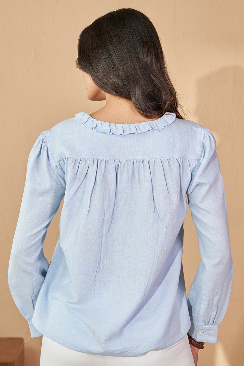 Pastel blue cotton top in v neck with frill.
